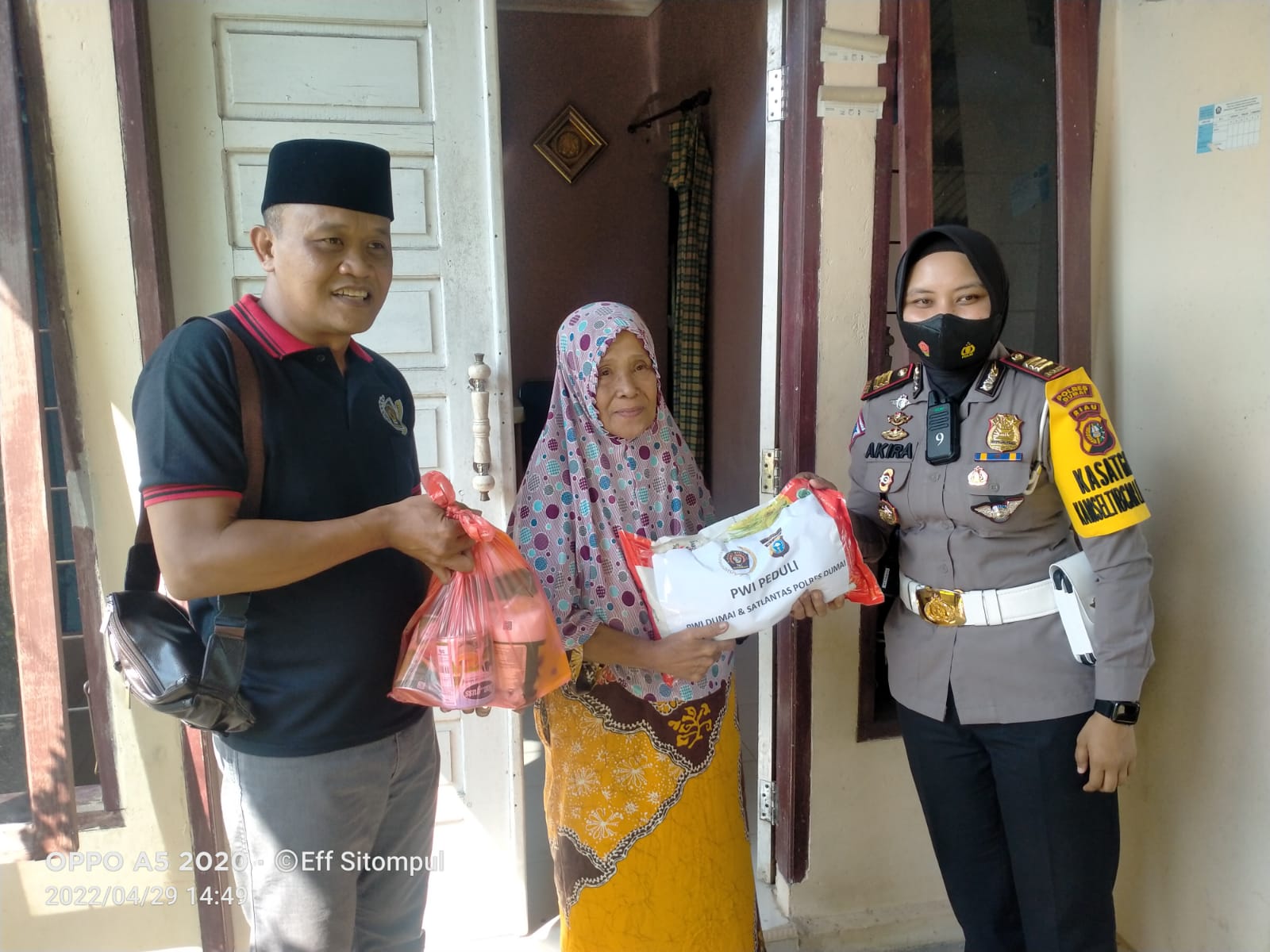 Foto Ketua PWI Dumai dan Kasat Lantas Polres Dumai membagikan bantuan