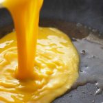 Foto kuning telor dalam proses dimasak