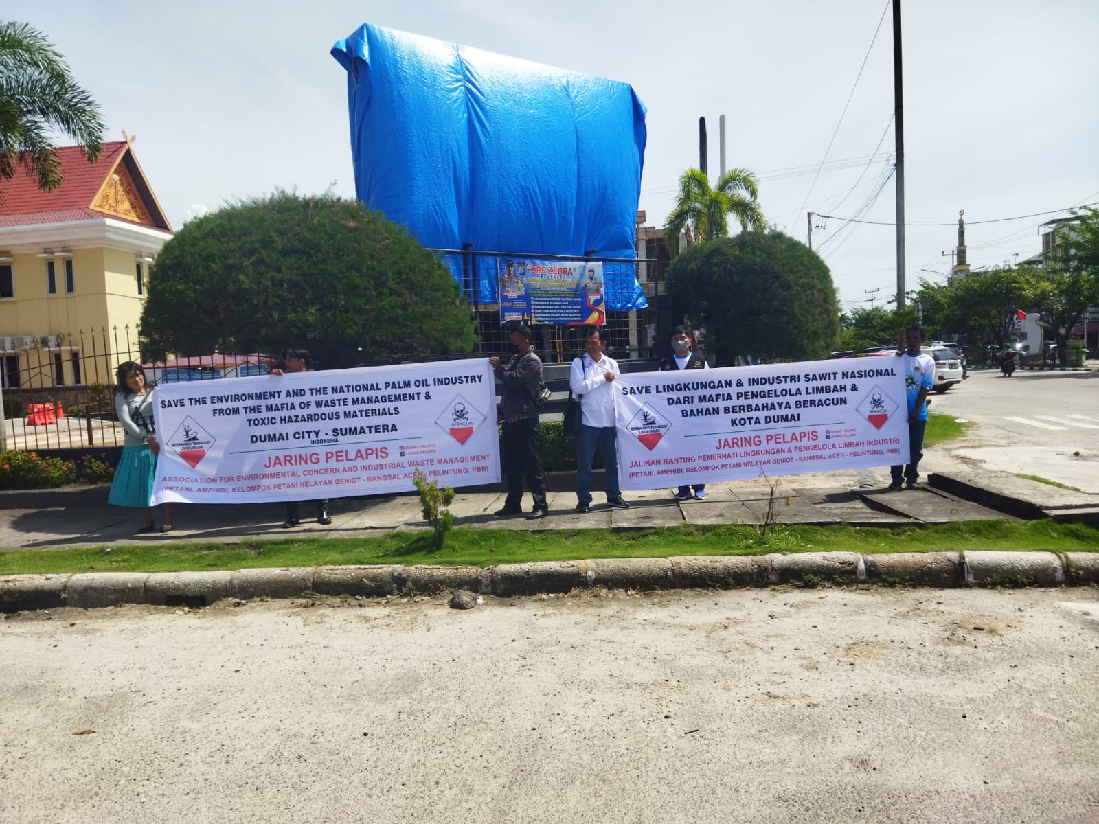 Foto aksi massa Jaring Pelapis saat memegang spanduk yang bertuliskan lindungi lingkungan.